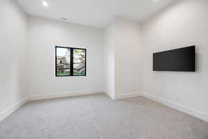 Spare room featuring light colored carpet and recessed lighting