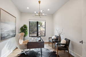 Home office featuring wood finished floors, recessed lighting, and a chandelier