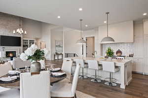 Dining space with a fireplace, dark wood-style flooring, and recessed lighting