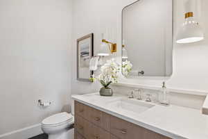 Half bathroom with vanity and toilet