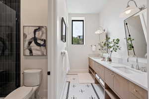 Full bathroom with double vanity, light tile patterned floors, and tiled shower