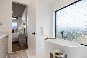 Full bath with ensuite bathroom, a freestanding bath, vanity, wood ceiling, and lofted ceiling