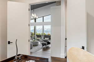 Corridor featuring dark wood-style floors, a chandelier, a mountain view, and a towering ceiling