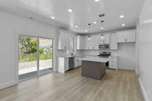 Kitchen with white cabinetry, appliances with stainless steel finishes, recessed lighting, a center island, and pendant lighting