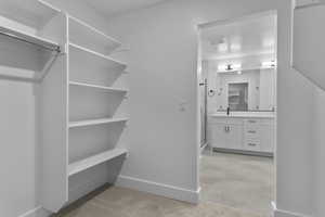 Spacious closet featuring light carpet and light tile patterned flooring