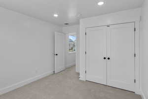Unfurnished bedroom featuring carpet floors, a closet, and recessed lighting
