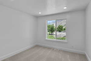Carpeted empty room with baseboards and recessed lighting