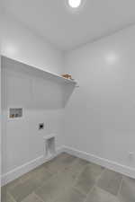 Laundry area featuring washer hookup, hookup for an electric dryer, and light tile patterned flooring