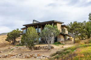 View of home's exterior with stone siding and a balcony