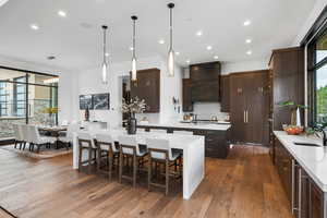 Kitchen with pendant lighting, light stone countertops, dark wood-style floors, and recessed lighting