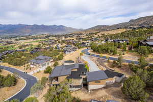 Aerial view of property and surrounding area with mountains and nearby suburban area