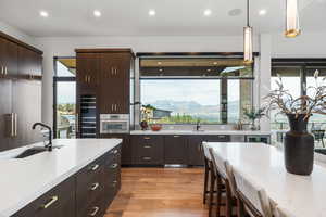 Kitchen with dark brown cabinets, healthy amount of natural light, decorative light fixtures, and recessed lighting