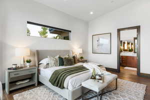 Bedroom featuring dark wood-style flooring, ensuite bathroom, and recessed lighting