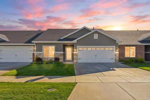 Craftsman house featuring a garage, a front yard, stucco siding, concrete driveway, and roof with shingles