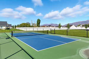 View of tennis court with community basketball court, a residential view, and a mountain view