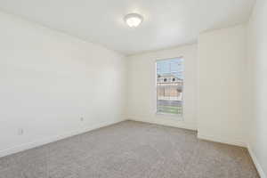 Spare room featuring light colored carpet and baseboards