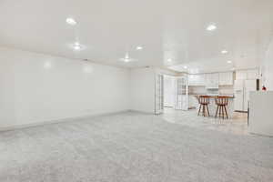 Living area featuring light carpet, recessed lighting, french doors, and light tile patterned floors