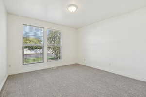 Spare room featuring light carpet and baseboards