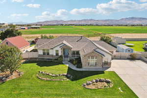 View of front of house featuring stone siding, concrete driveway, a mountain view, and a view of countryside
