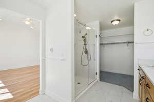 Bathroom with vanity, a stall shower, and a walk in closet