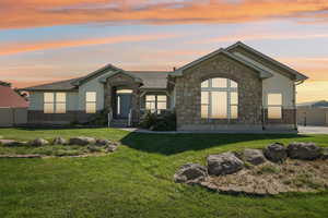 Single story home with stone siding, a gate, and a shingled roof