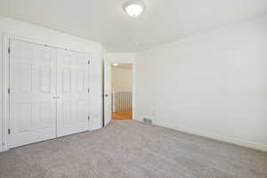 Unfurnished bedroom featuring carpet and a closet