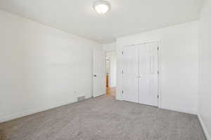 Unfurnished bedroom with carpet and a closet
