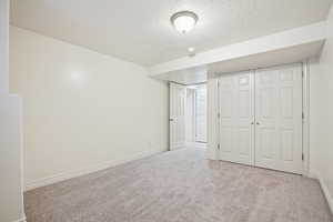Unfurnished bedroom with a textured ceiling, carpet, and a closet