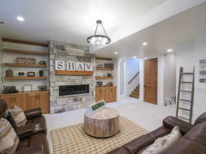 Living area with a fireplace, recessed lighting, light colored carpet, built in shelves, and stairs