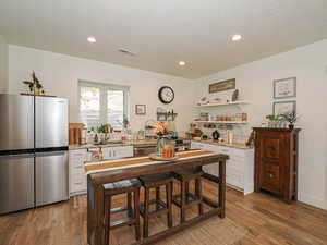 Dining area featuring a textured ceiling, wood finished floors, and recessed lighting