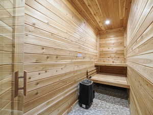 Sauna featuring wood walls, wooden ceiling, and recessed lighting