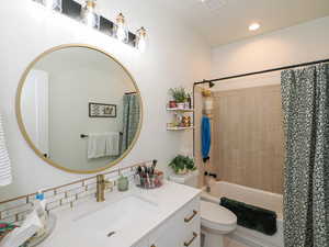 Bathroom with shower / bath combination with curtain, vanity, and recessed lighting