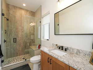 Bathroom featuring vanity, a shower stall, light tile patterned flooring, and recessed lighting
