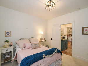 Bedroom featuring light carpet and baseboards