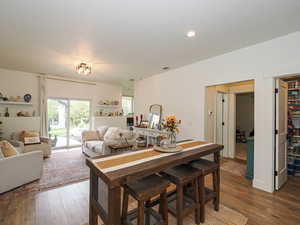 Dining room featuring dark wood-style floors, a textured ceiling, and recessed lighting