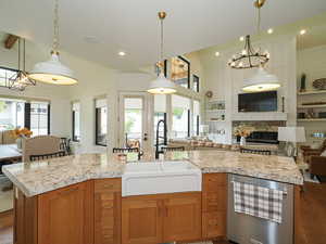 Kitchen featuring brown cabinets, open floor plan, light countertops, dark wood-type flooring, and a high ceiling