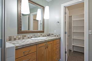 Bathroom featuring vanity and a closet