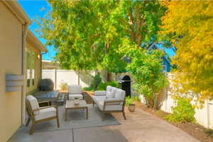 Fenced backyard with a patio, an outdoor hangout area, and grilling area