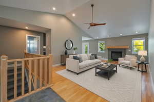Living room featuring recessed lighting, wood finished floors, a tiled fireplace, high vaulted ceiling, and a ceiling fan