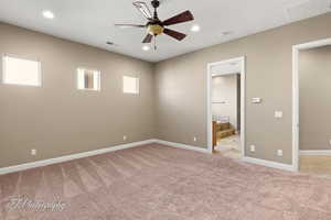 Unfurnished bedroom with light carpet, recessed lighting, ceiling fan, and ensuite bathroom
