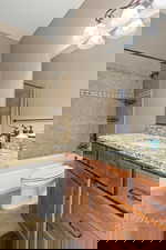 Full bath with shower / bathtub combination with curtain, vanity, and light tile patterned flooring