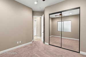 Unfurnished bedroom featuring light carpet, ceiling fan, a closet, and recessed lighting
