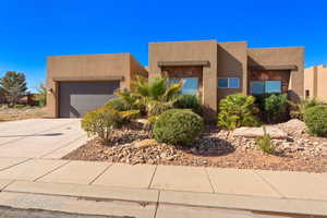 Southwest-style home with stucco siding, concrete driveway, and a garage