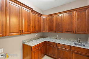 Kitchen with light stone counters and brown cabinets