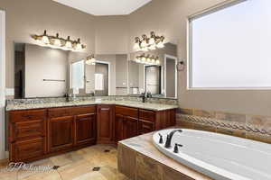 Bathroom featuring double vanity and a bath