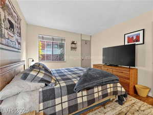 Bedroom featuring wood finished floors and a textured ceiling