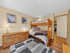 Bedroom with wood finished floors and a textured ceiling