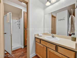 Full bathroom featuring a stall shower, vanity, and dark wood-style flooring