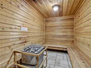 Relaxing sauna featuring wooden ceiling and wood walls
