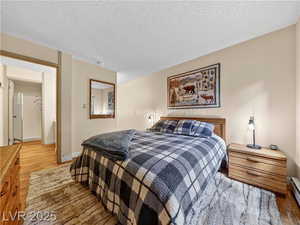 Bedroom featuring wood finished floors and a textured ceiling